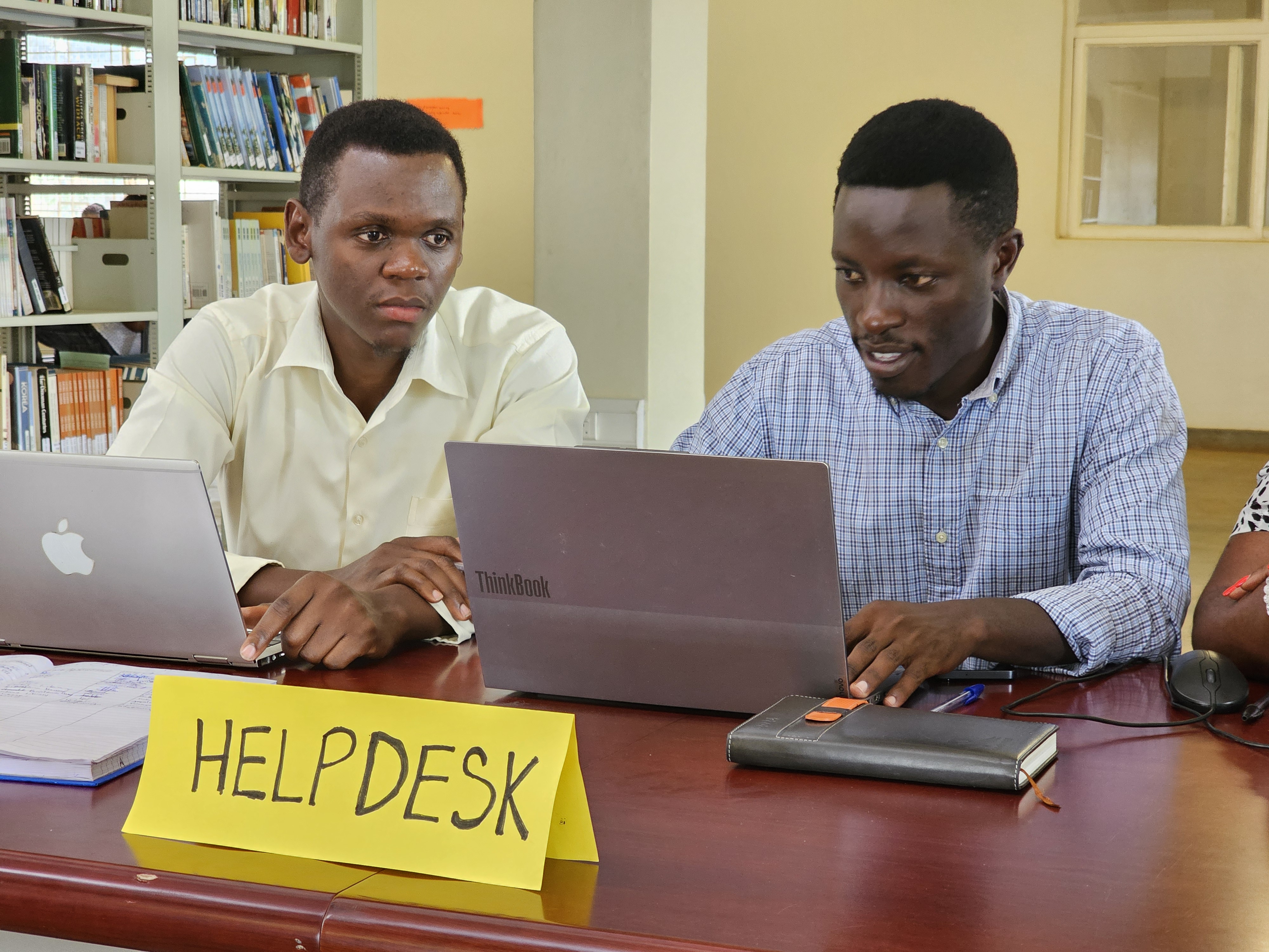 Student receiving assistance at a help desk inside the Busitema University Library.