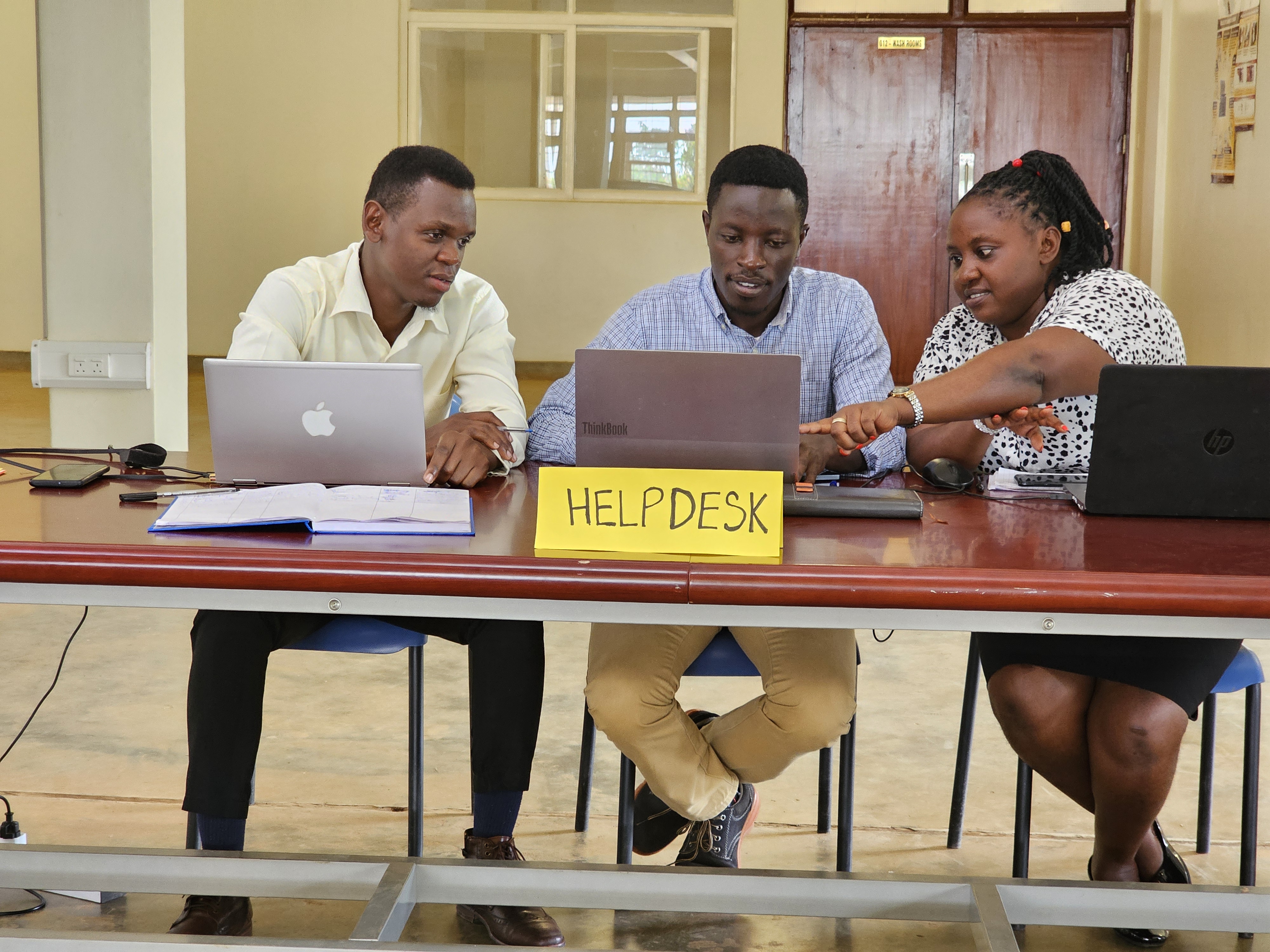 Student receiving assistance at a help desk inside the Busitema University Library.